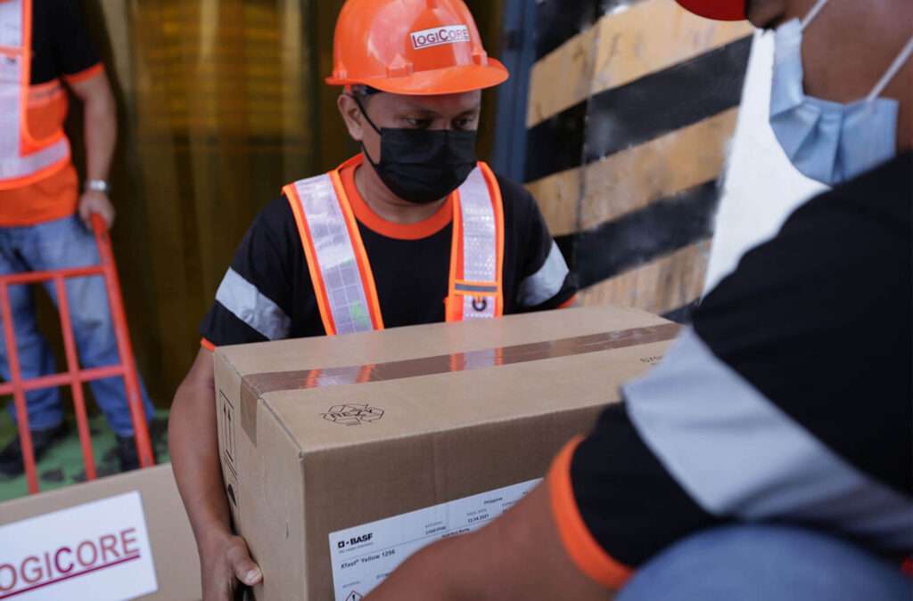 LogiCore's employee on duty lifting boxes for dry storage